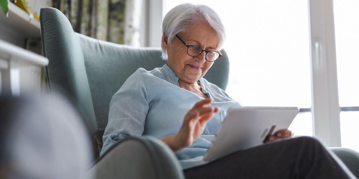 senior internet plans woman in chair using tablet