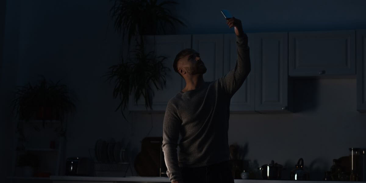man looking at phone in power outage