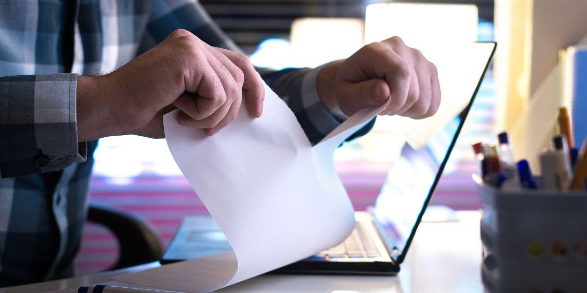 person tearing up paper