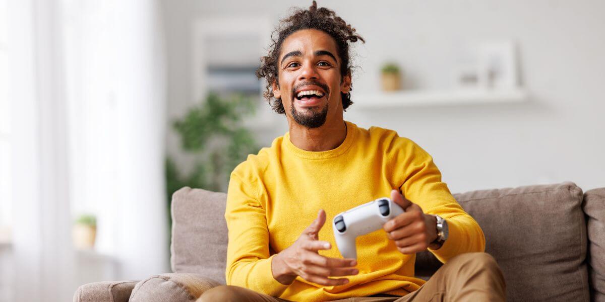 person playing PS5 on couch