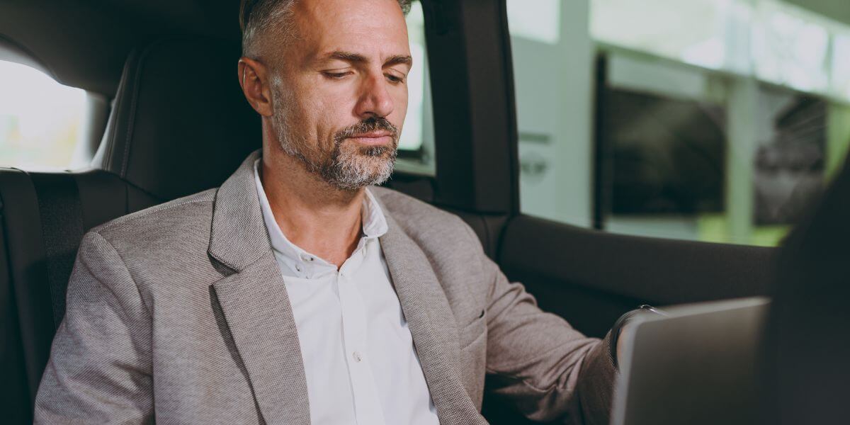 man using laptop in car