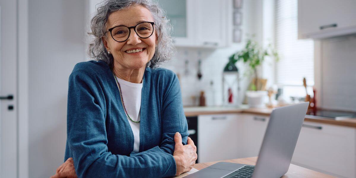 senior woman smiling at laptop