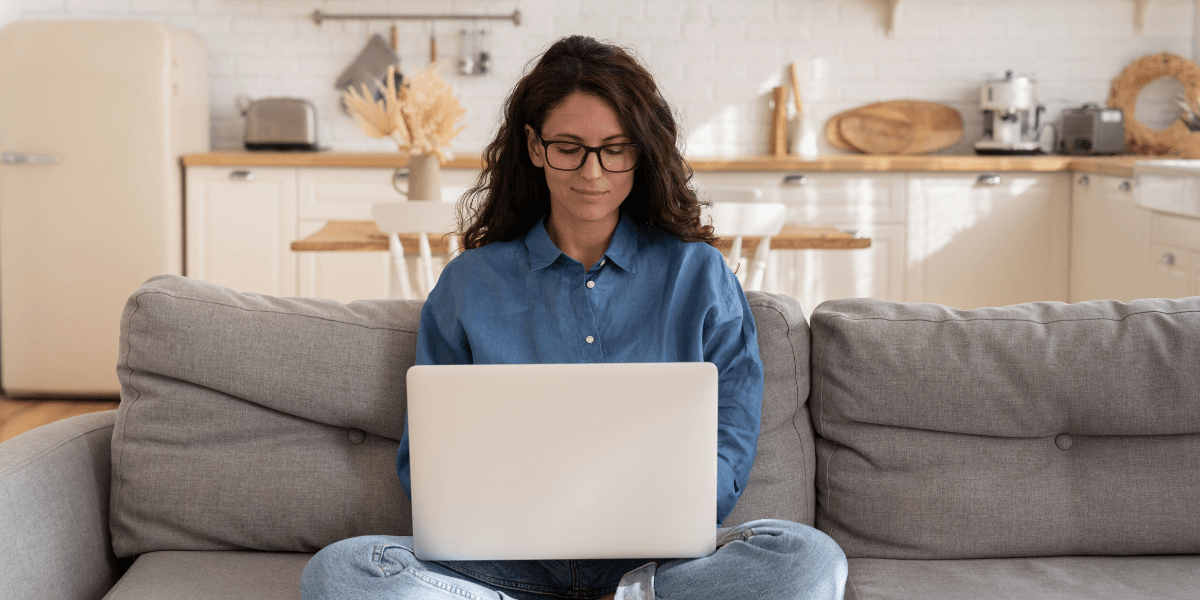 woman working on laptop from her couch