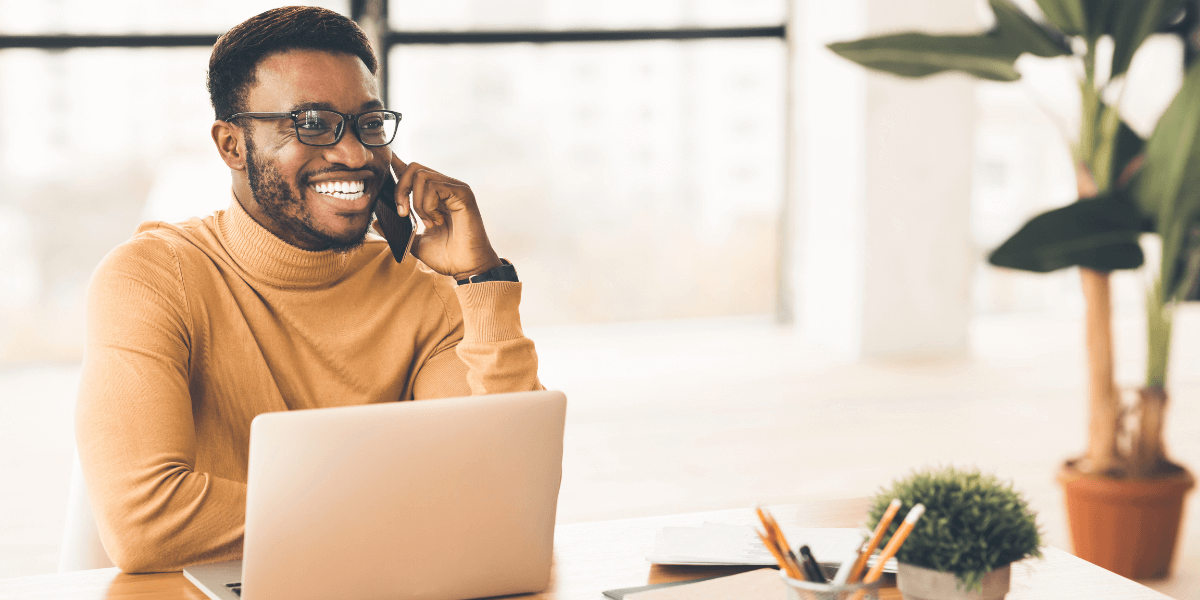 man on the phone with laptop in front of him