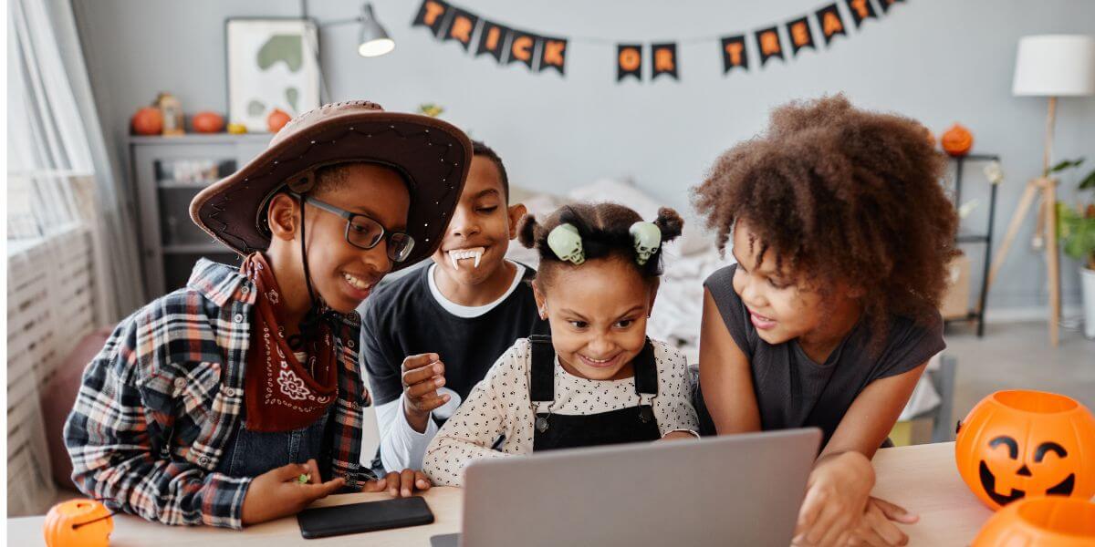 children at laptop with halloween decorations