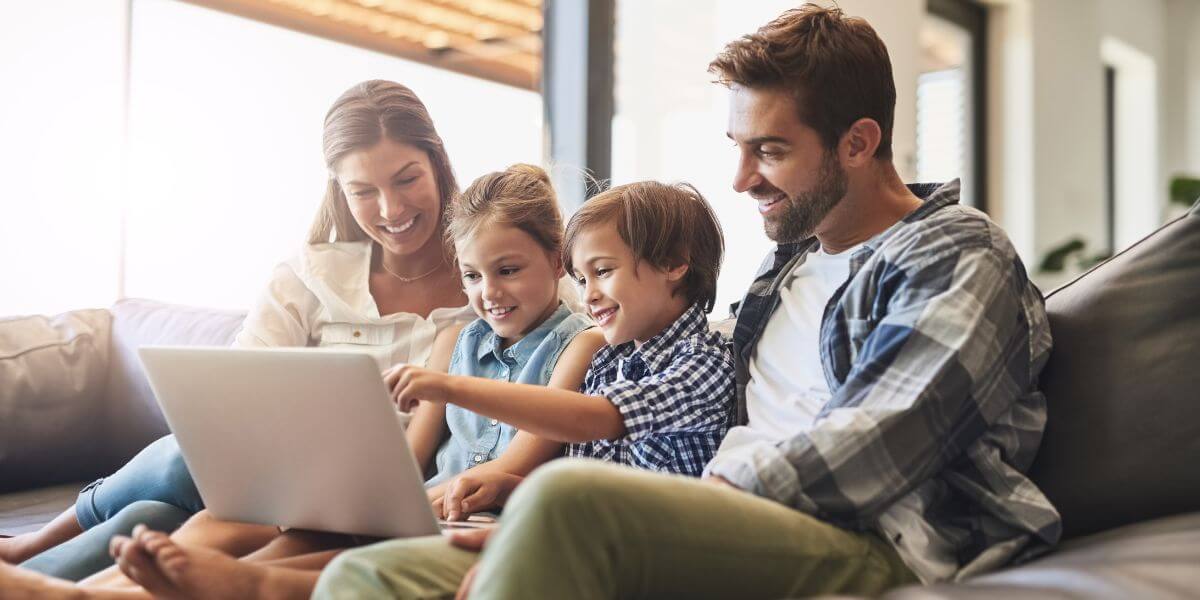 family using laptop on couch