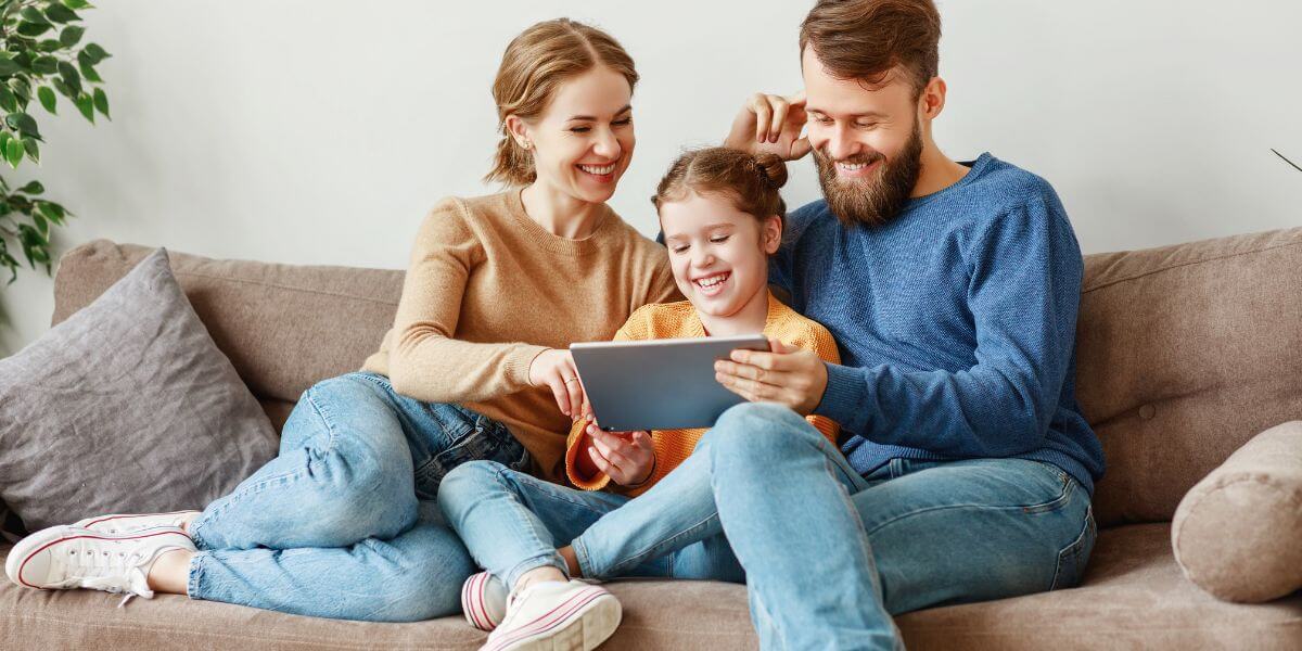 family using tablet on couch