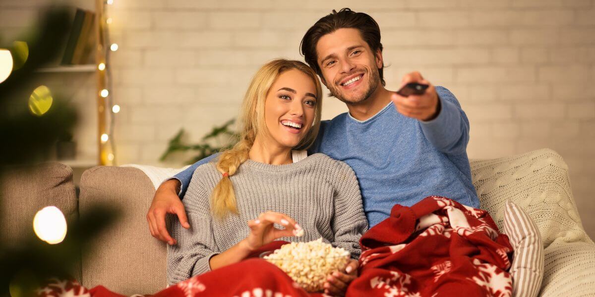 holiday couple watching tv on couch