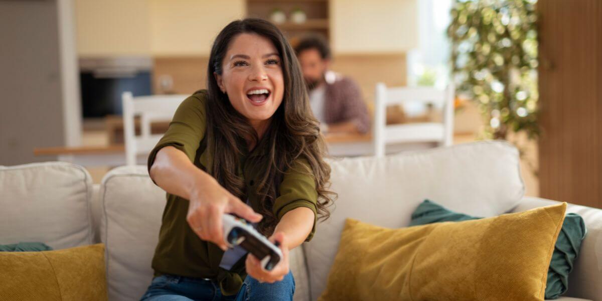 woman playing PS5 on couch