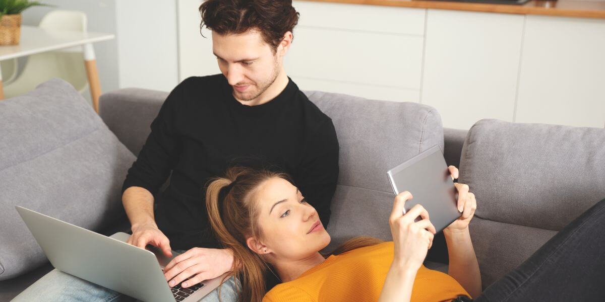 couple on couch using devices