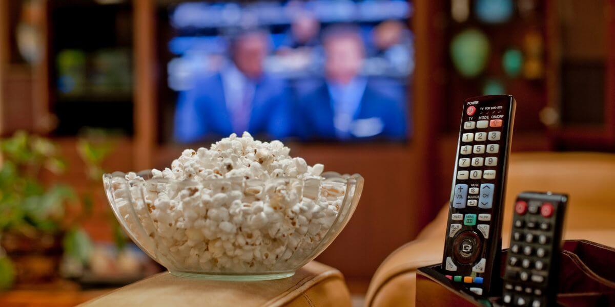 tv in background with popcorn and remotes