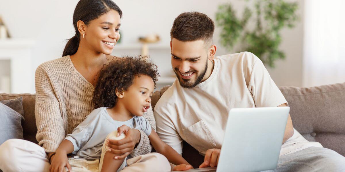 family on couch using laptop