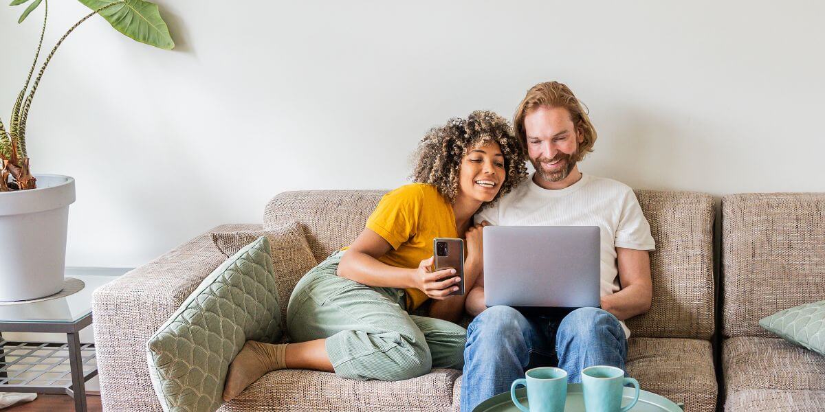 couple on couch using laptop