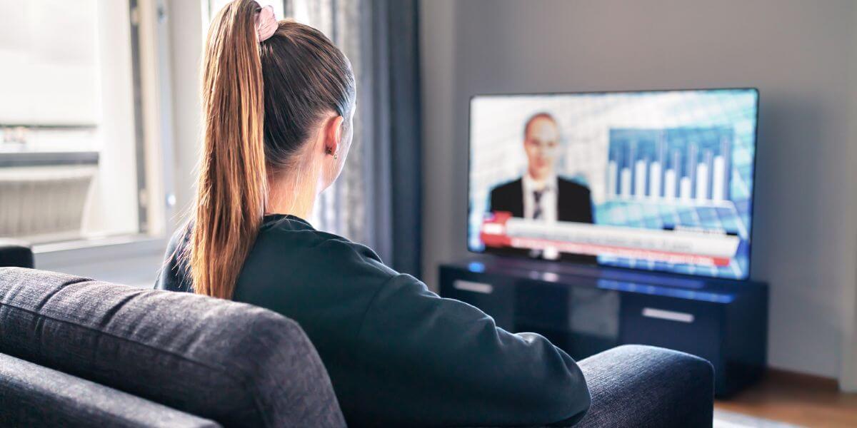 person watching news on couch