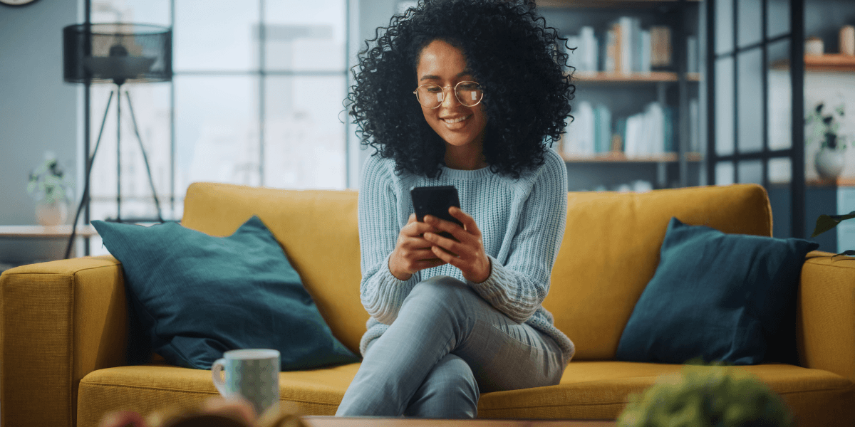 woman smiling looking at her phone