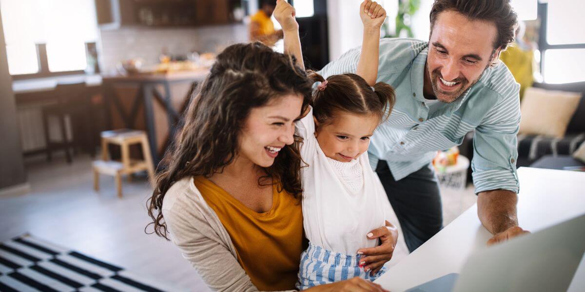 family laughing at laptop