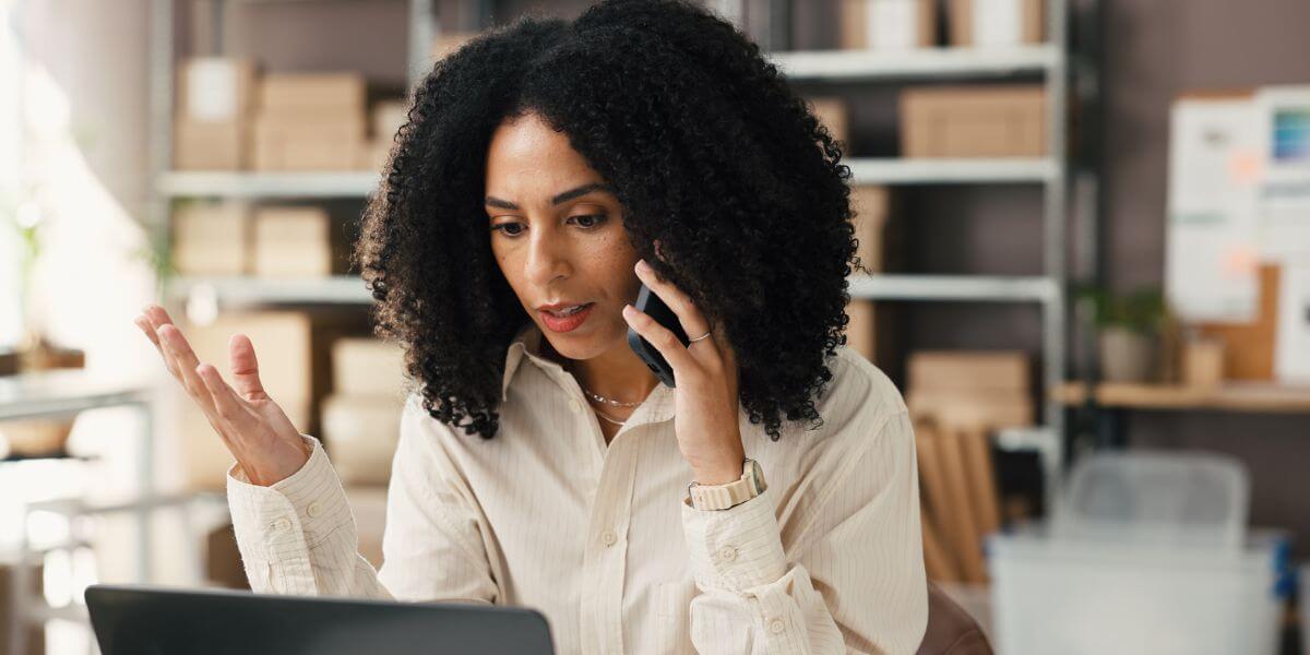 woman on phone using laptop