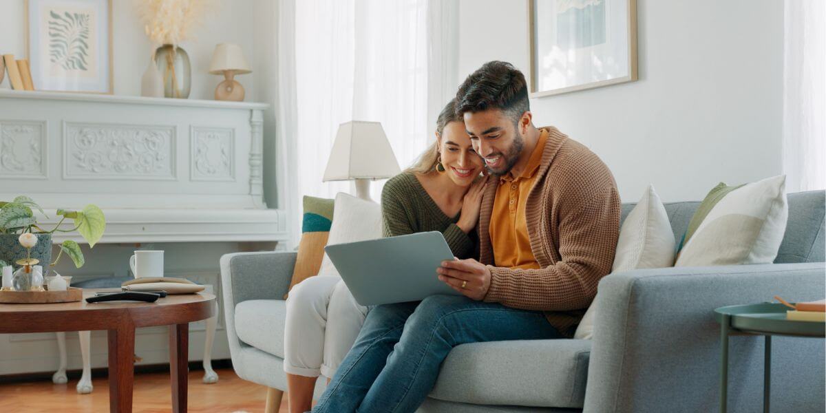 couple using laptop on couch