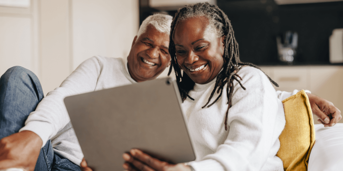two people smiling at computer