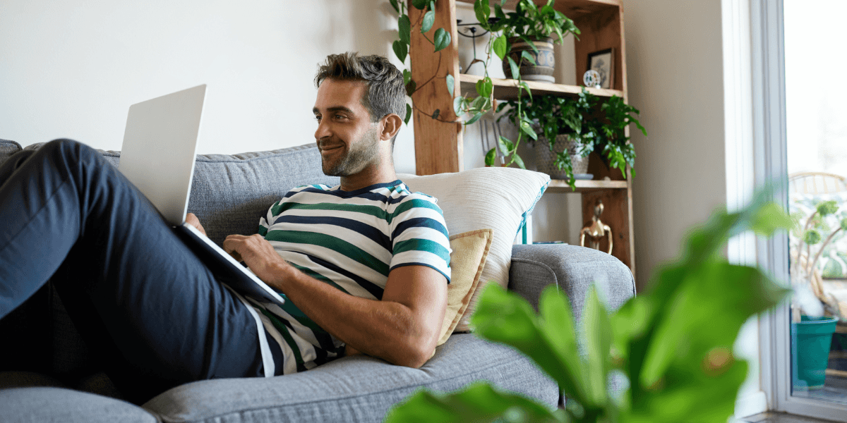 man looking at laptop on couch