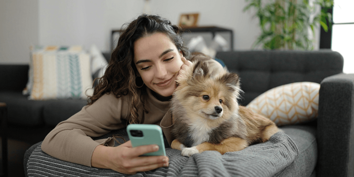 young woman and her dog looking at her phone