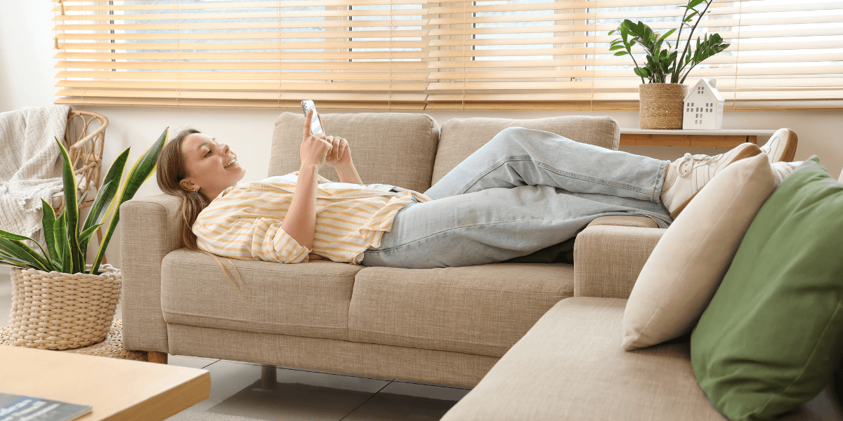 girl laying on couch using her phone