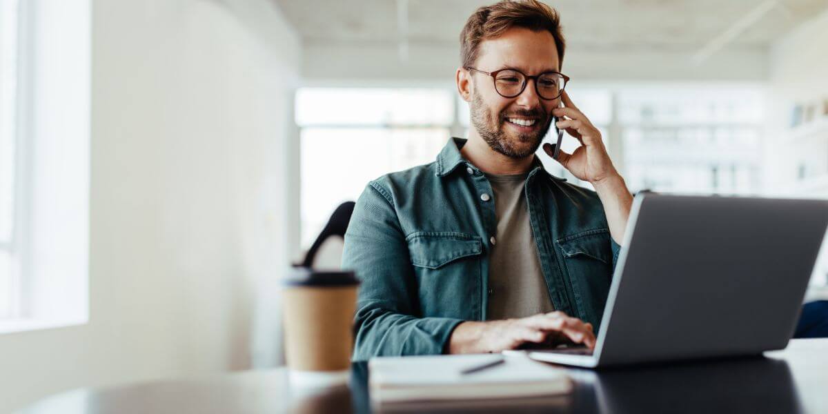 man on phone using laptop