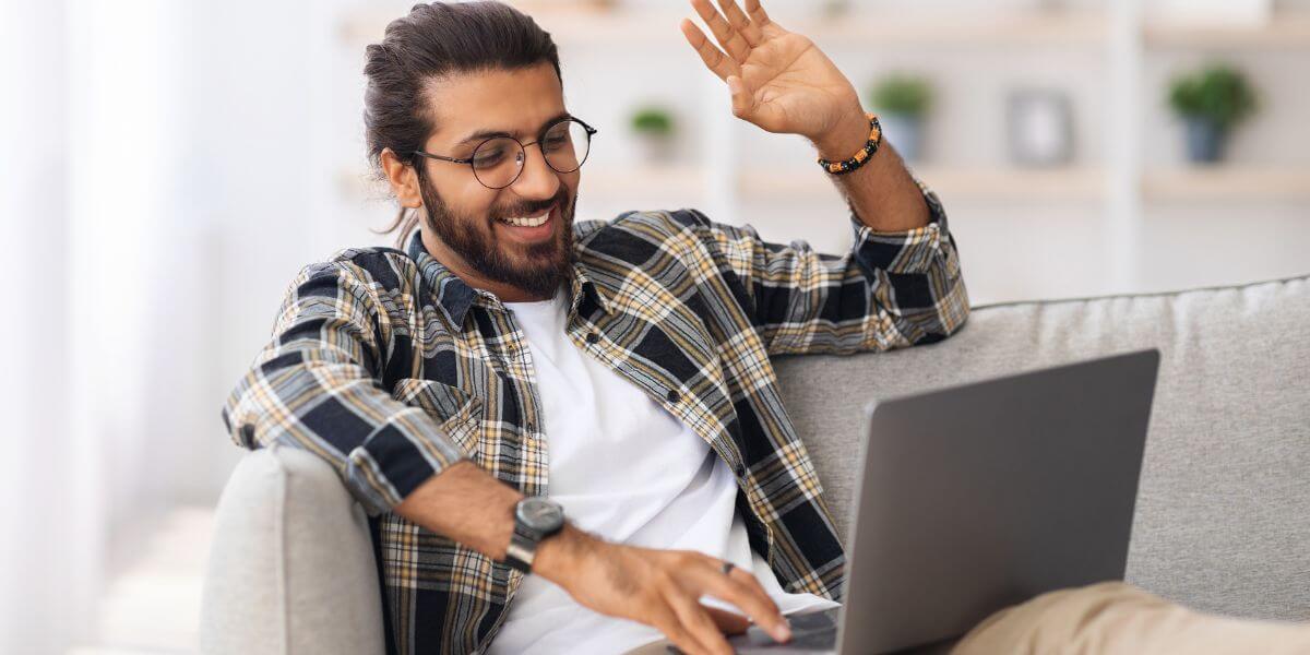 man waving at laptop
