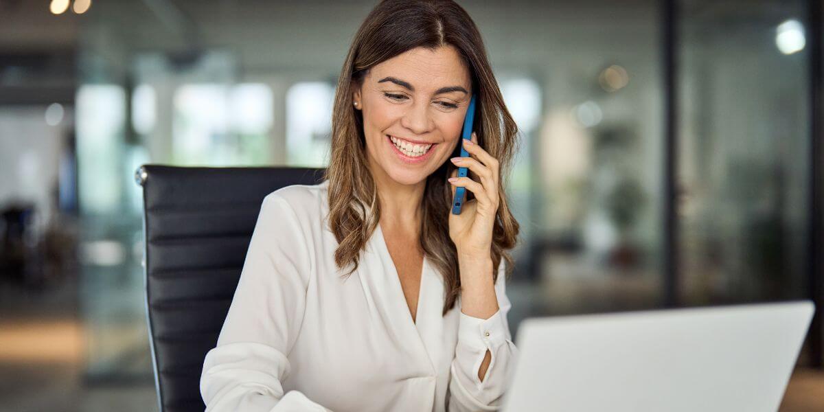 woman on phone using laptop