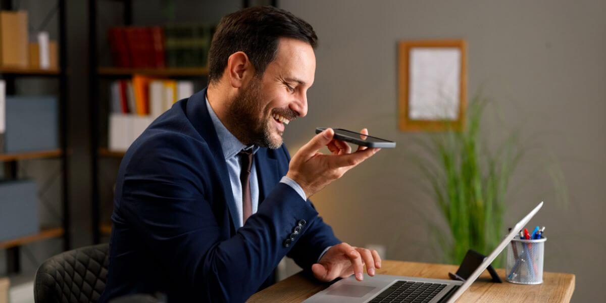 man using phone and laptop