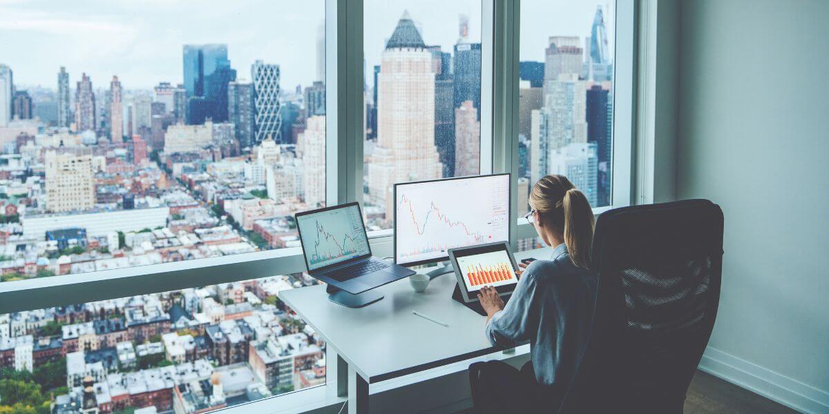 woman using laptop at table overlooking city