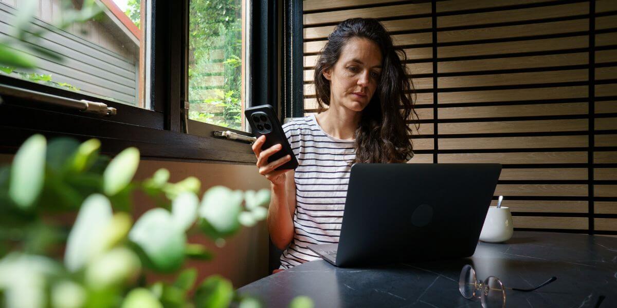 woman using phone and laptop