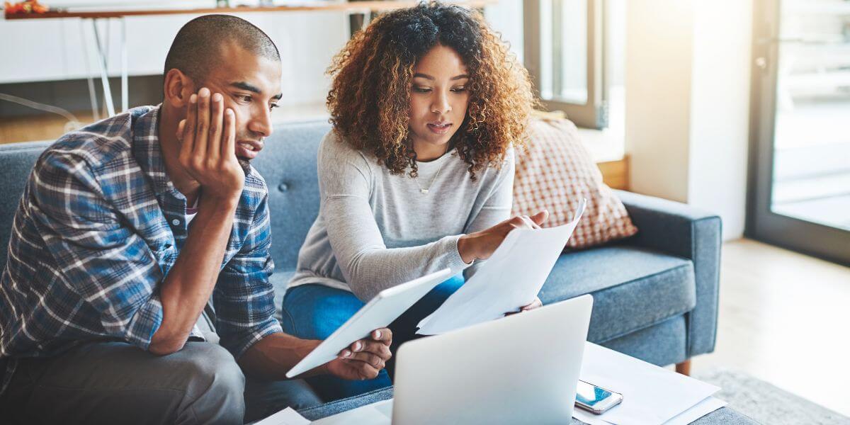 couple on couch paying bills