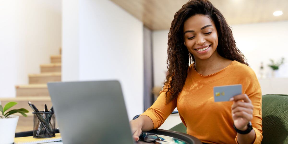 woman looking at laptop holding gift card
