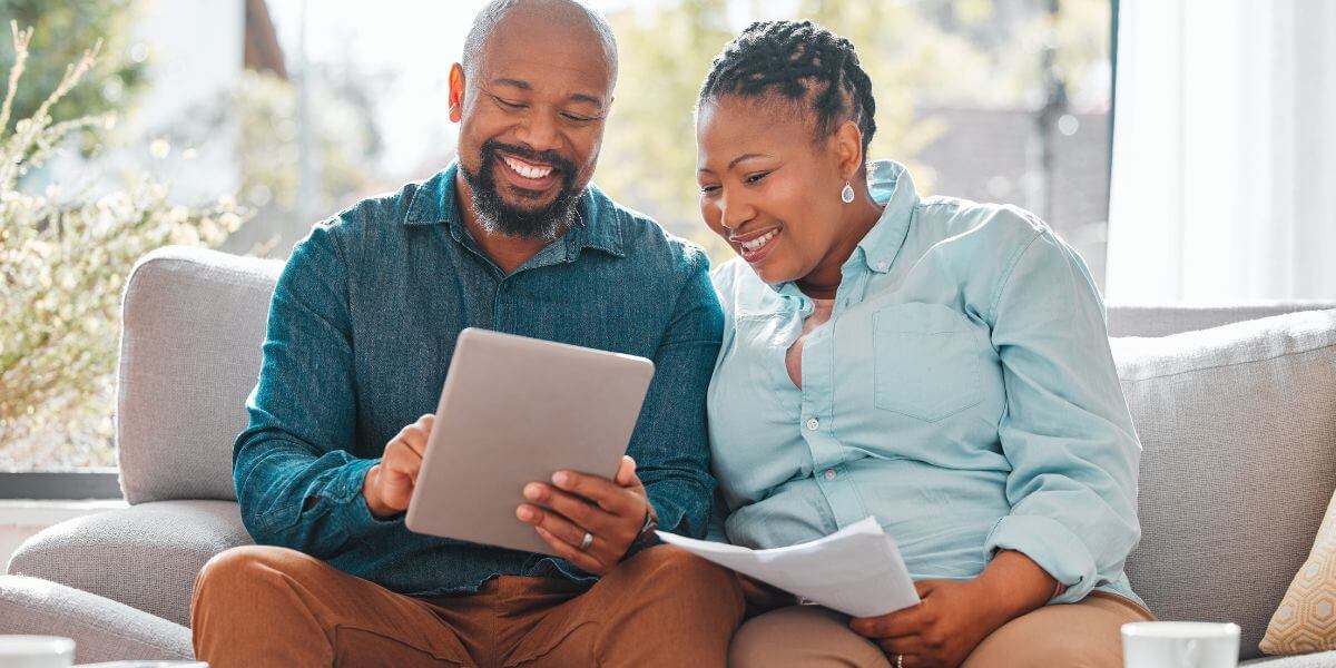 couple smiling looking at tablet