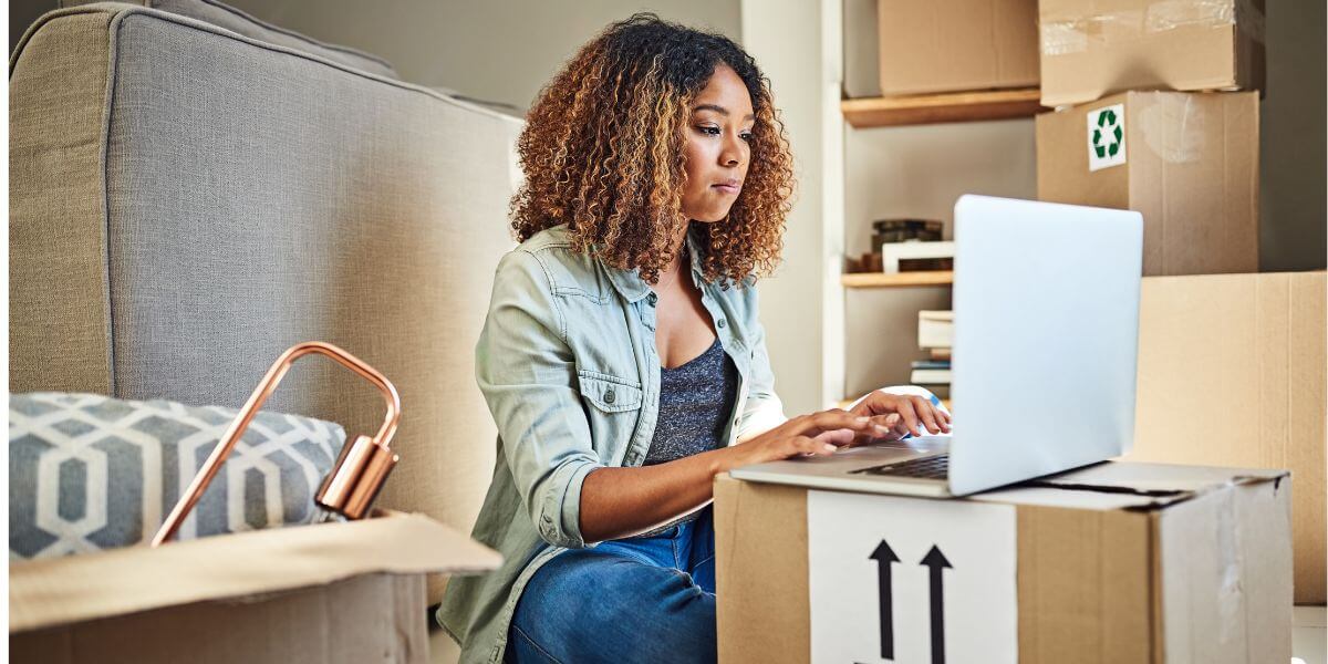 woman using laptop on boxes