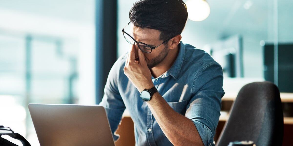 man frustrated at laptop