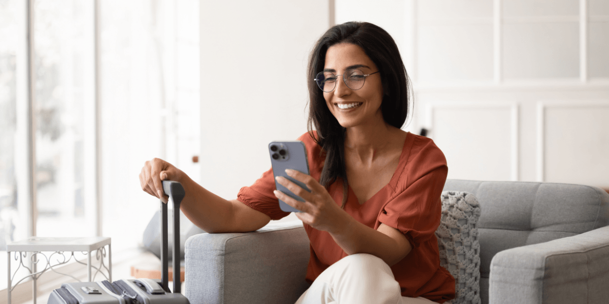 person looking at phone with suitcase