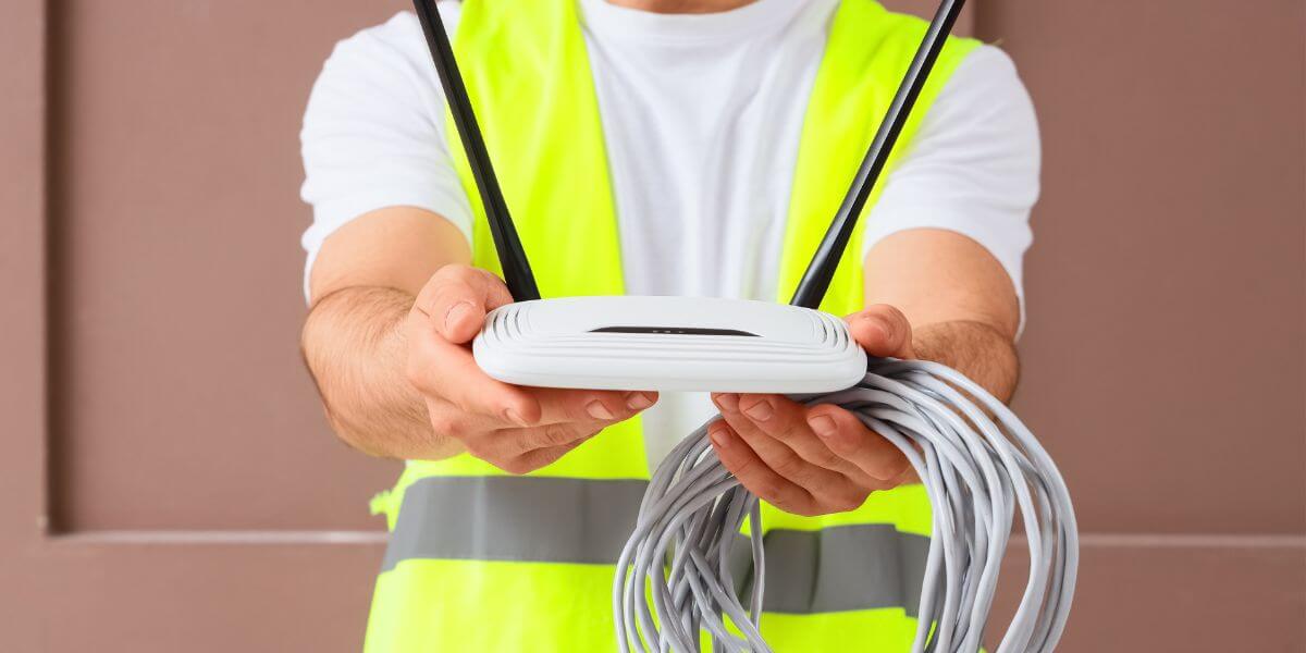 person holding router and ethernet