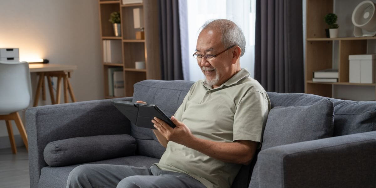 man using tablet on couch