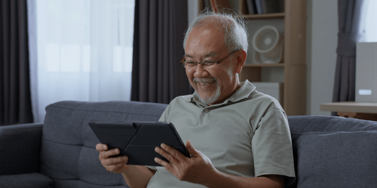 man using a tablet while sitting on the couch