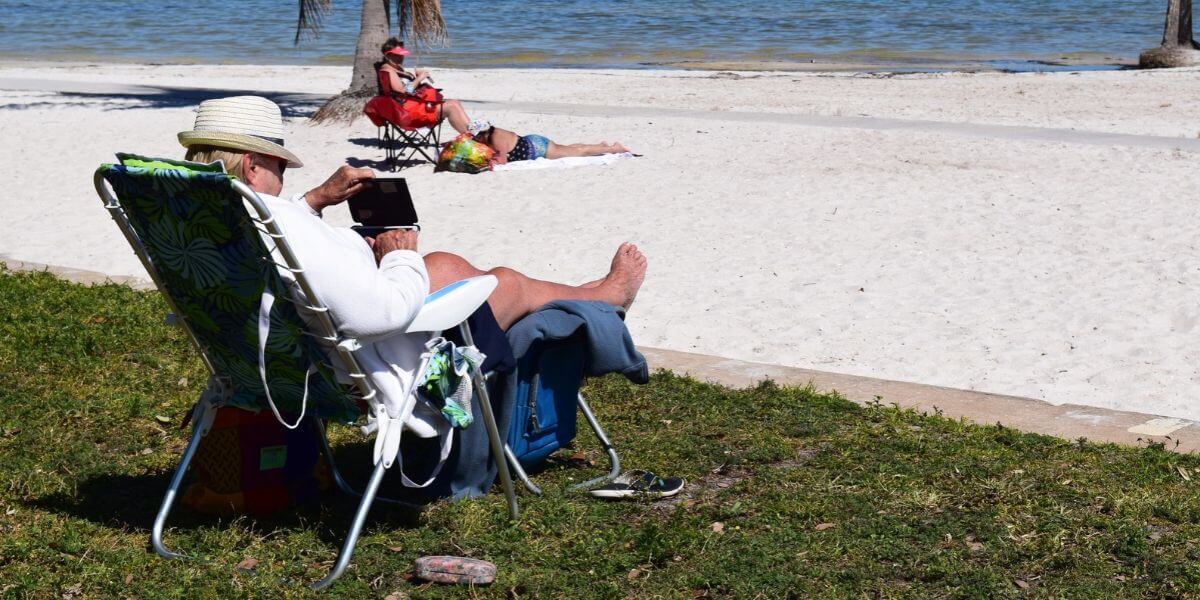 man using laptop at beach