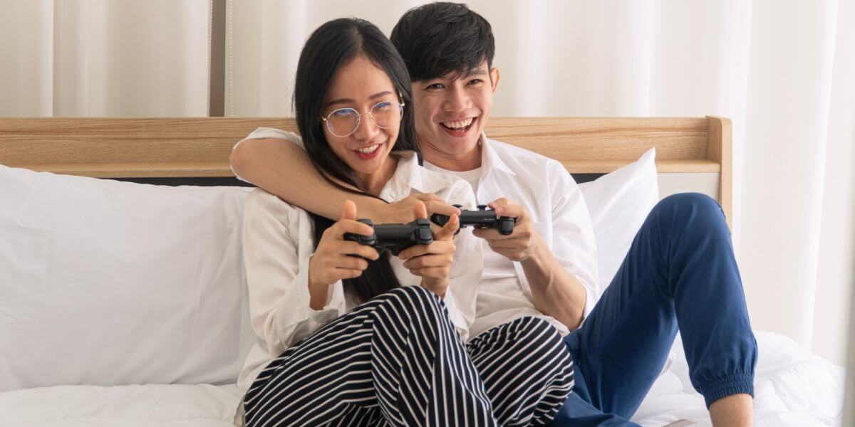 people playing video games on bed