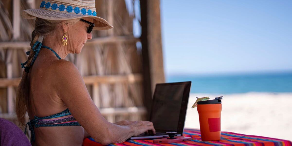 woman using laptop at beach