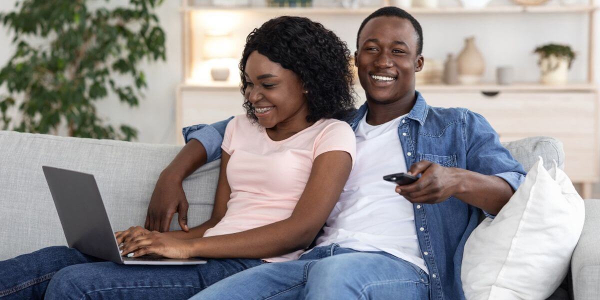 two people on couch with laptop